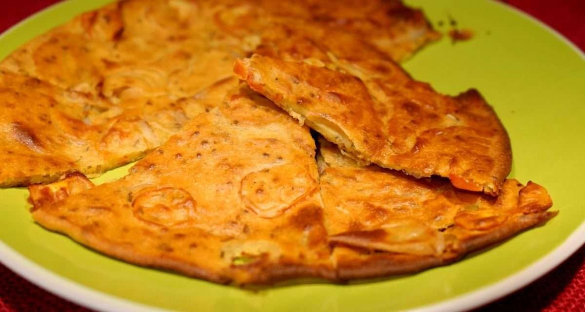 Schiacciata con farina di ceci, cipolla e pomodori